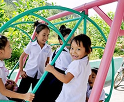 写真：校庭の遊具で遊ぶ子供たち